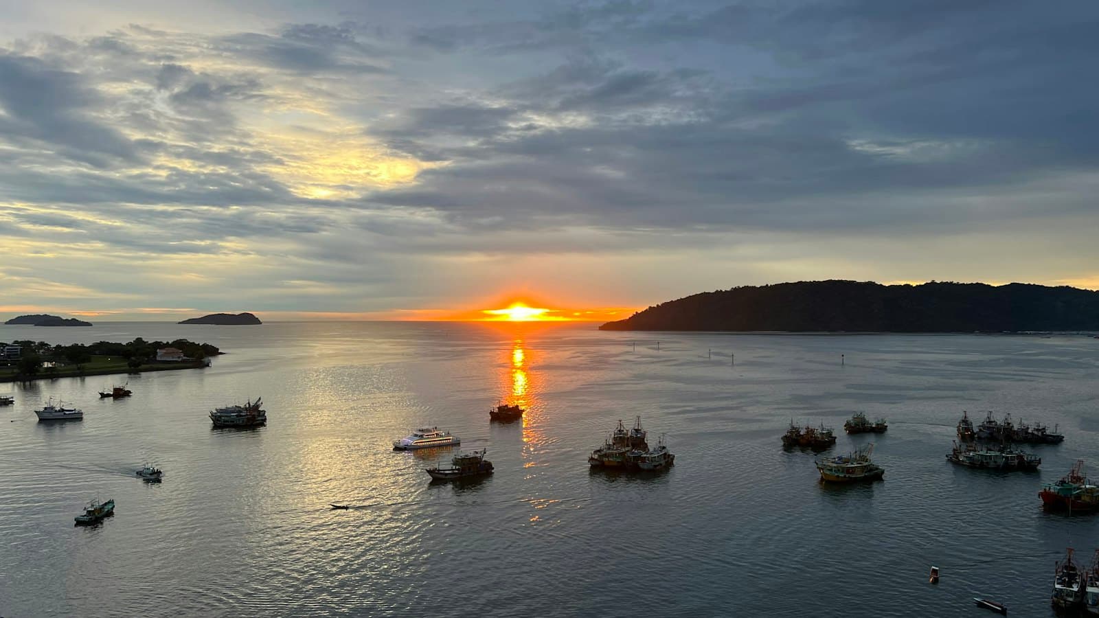 Sunset over Kota Kinabalu bay with boats at anchor
